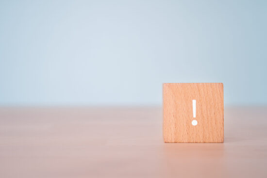 机の上に置かれた！マークが書かれた木のブロック