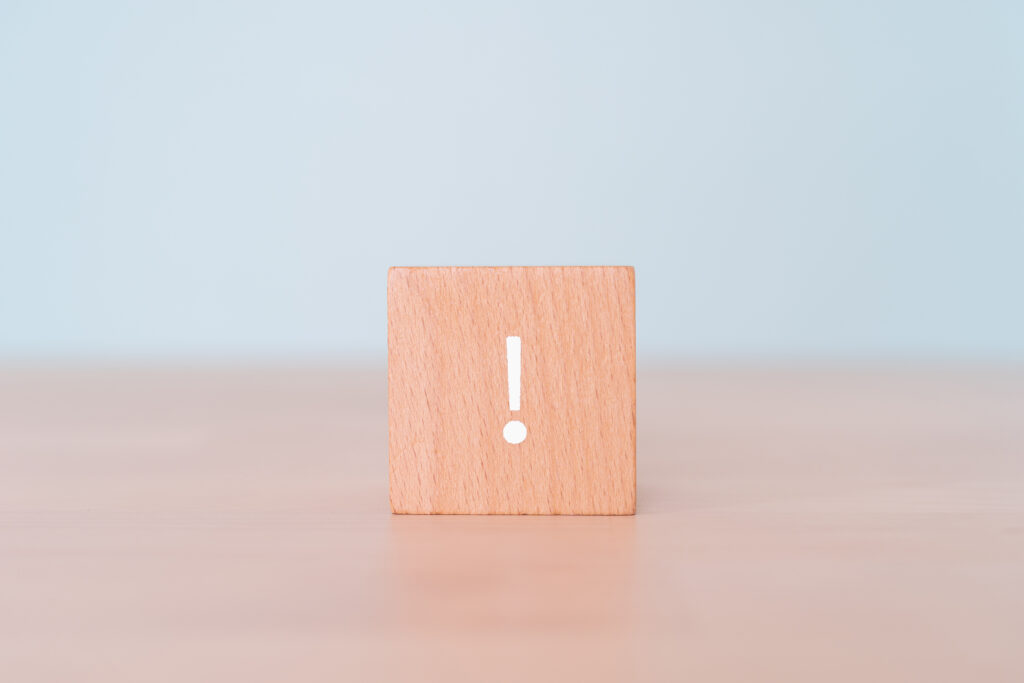 机に置かれた!マークの木のブロック