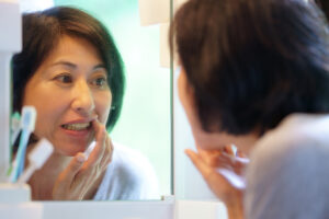 鏡で歯の状態を確認する女性