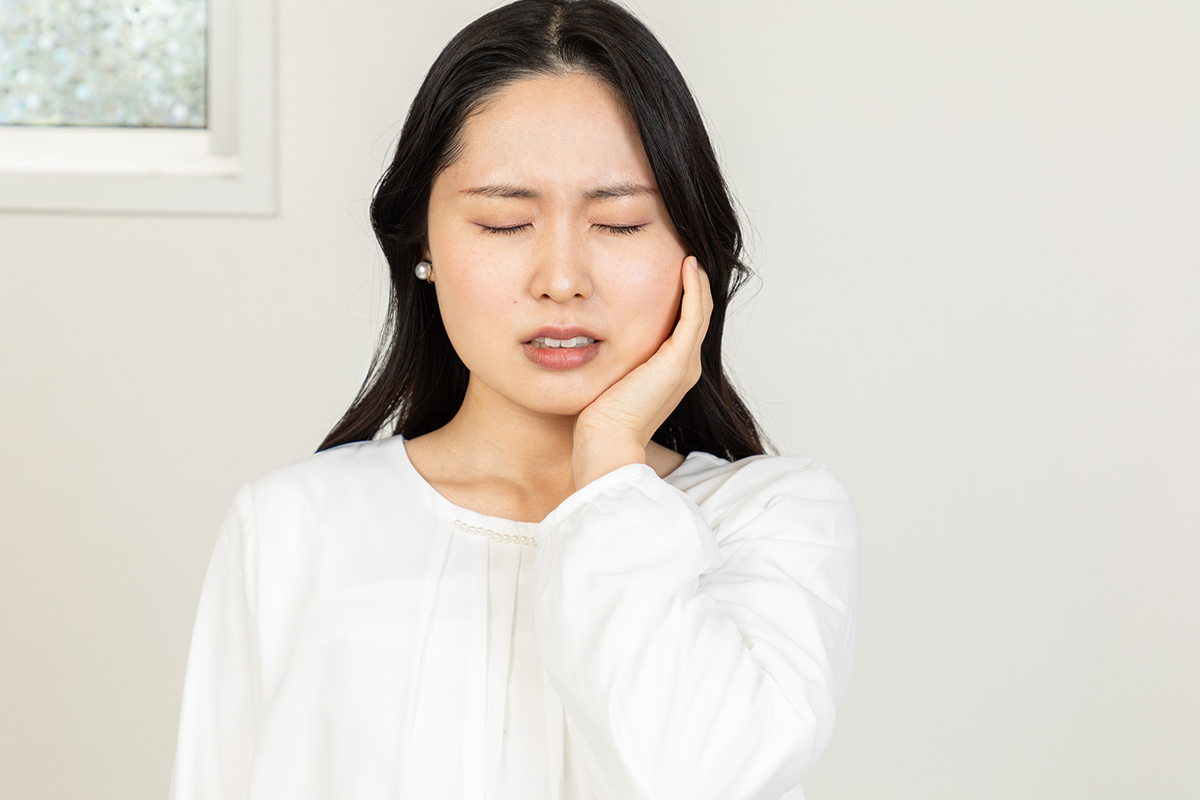 虫歯で痛みを我慢する女性
