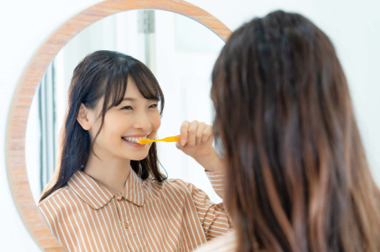 歯周病の進行を防ぐために正しい方法で歯をみがく女性