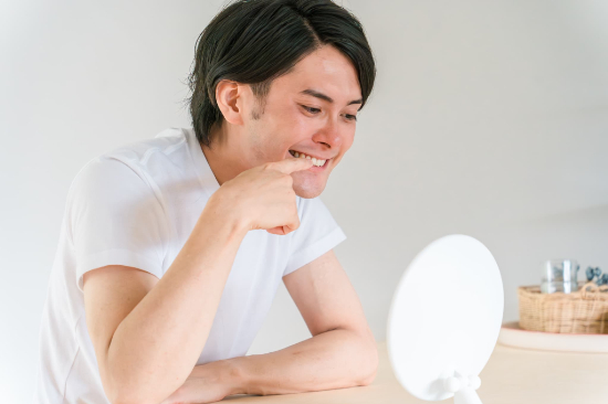 出っ歯かもと鏡でチェックする男性