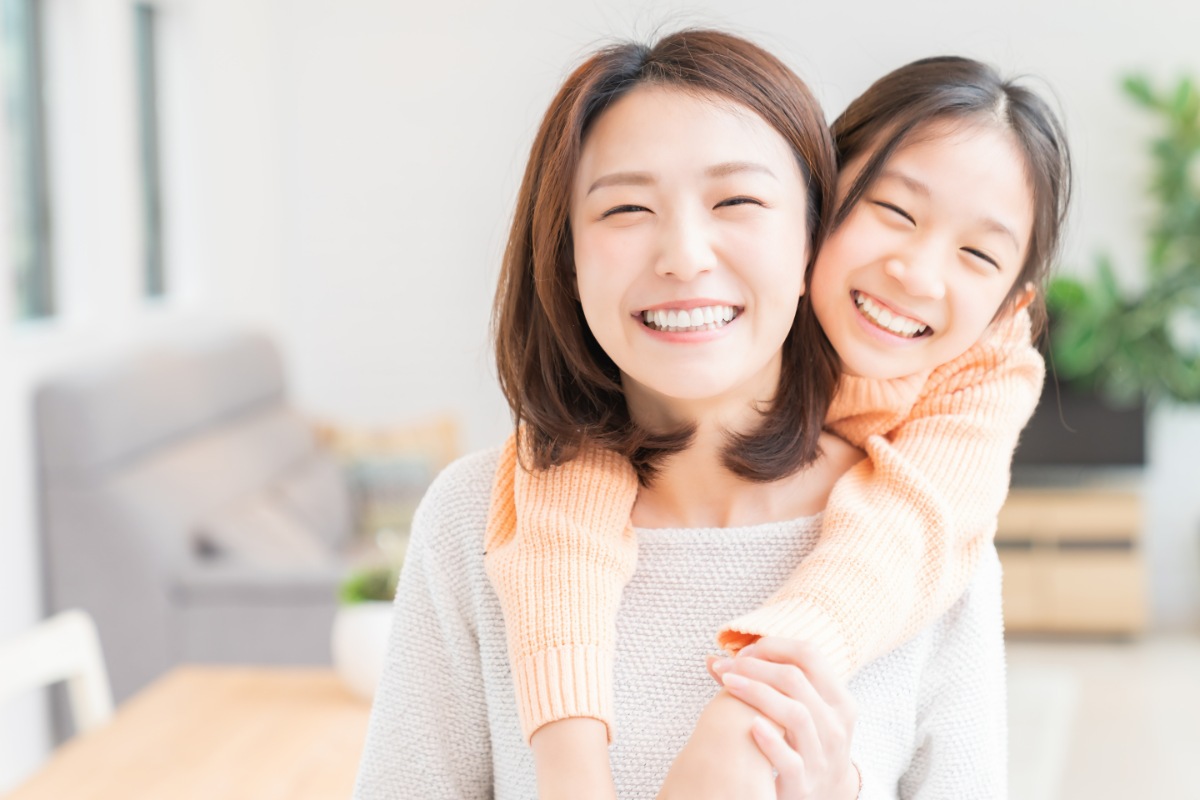定期的に歯科検診を受けてきれいな歯で笑顔の女の子と母親